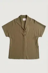 Sobrecamisa roja de lino de manga corta, con cuello solapa, costuras decorativas en contraste y cierre frontal con presillas y botones alargados.
