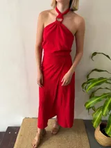 Conjunto de dos piezas color rojo. Incluye un top halter con argolla decorativa en el escote y lazo ajustable en el contorno. La falda es larga, recta y de diseño cruzado regulable.