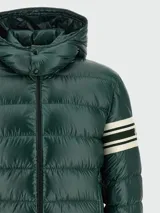 Campera puffer con capucha, color verde oscuro, con diseño acolchado horizontal y detalle de bandas blancas en la manga izquierda.