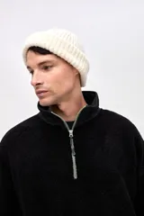 Buzo de sherpa con textura capitoneada, diseño de medio cierre y cuello alto en color beige contrastante. Presenta un calce holgado, mangas largas con puños elásticos y bolsillos laterales.