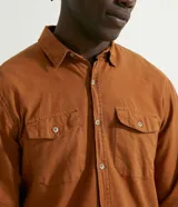 Camisa de manga larga de algodón oxford color marrón, de corte casual, con bolsillos frontales con solapa y cierre de botones.