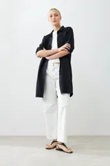 Túnica negra con bordados y bolsillos laterales.