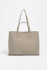 Bolso shopper de tamaño grande con estructura blanda, confeccionado en nylon. Cuenta con doble asa de hombro, cierre con mosquetón y logo metálico de la marca en la parte frontal.