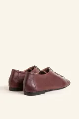 Zapato tipo oxford plano de cuero vacuno en color azul marino, con cordones al tono y suela de cuero.