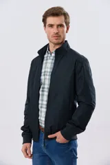 Campera liviana de nylon color azul marino, con cuello alto, cierre frontal y puños y dobladillo en elástico tejido.