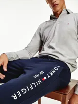 Pantalón de jogging azul marino de algodón orgánico, con corte cónico, cintura elástica con cordón, bolsillos laterales y trasero, y logo de Tommy Hilfiger estampado en la pierna.