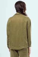 Camisa negra de manga larga con cuello en V, cierre frontal de botones y costuras decorativas en contraste de color blanco.