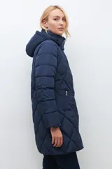 Campera acolchada de largo medio, color azul marino, con diseño de rombos. Posee cuello alto y capucha desmontable.