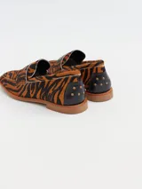 Mocasines de cuero con estampado animal print de tigre en tonos marrones y negros. Diseñados en Uruguay y producidos en Brasil.