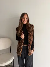 Chaleco de piel sintética con estampado animal print de leopardo, sin mangas y diseño largo.
