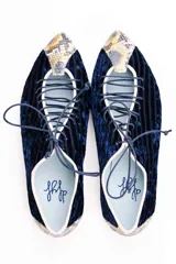 Zapato tipo blucher de terciopelo de seda azul marino con diseño rayado. Presenta una abertura central ajustable con cordones, ribetes en contraste y detalles en piel con estampado de pitón multicolor en la puntera y el talón. Cuenta con suela de cuero.