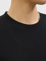 Remera de manga corta y cuello redondo con calce relajado, confeccionada en tejido con textura sutil. Diseño básico y versátil.