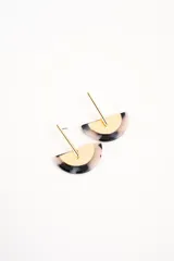 Aros colgantes compuestos por una pieza semicircular de resina con patrón carey en tonos grises y blancos, combinada con un aplique metálico dorado de diseño geométrico.
