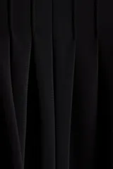 Pantalón negro de tiro alto confeccionado en punto interlock pesado. Cuenta con cintura elástica con pliegues cosidos alrededor, diseño de piernas barrel y puños elásticos ceñidos en los tobillos.