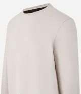 Buzo de algodón y poliéster color beige, con cuello redondo, mangas largas y puños ajustados. Diseño liso y minimalista.