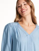 Blusa Zac & Rachel de lyocell color azul, con escote en V y panel central con pespuntes. Presenta mangas tres cuartos abullonadas con frunces en los hombros y puños elastizados con detalle de volante.