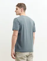 Camiseta de manga corta color verde agua, con cuello redondo y tapeta de dos botones.