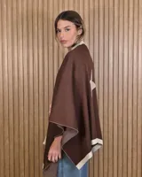 Ruana tejida de algodón en color marrón con detalles en off-white, destacando un diseño de estrella grande en la espalda y bordes en contraste.