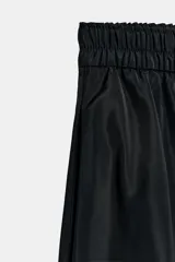 Falda midi de tiro medio color negro, con cintura elástica, bolsillos laterales ocultos y bajo con acabado en línea evasé.