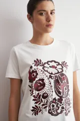 Remera blanca de manga corta con estampa damasco floral en tonos bordó y negro en el frente.