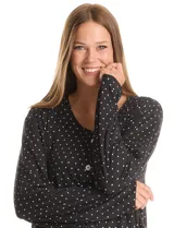 Conjunto de pijama de dos piezas compuesto por una remera de manga larga con escote en V, abertura central con botones y bolsillo aplicado, y un pantalón con cintura elastizada y lazo de ajuste. Presenta un diseño estampado de lunares blancos sobre fondo negro.