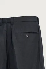 Pantalón de traje regular fit de lino color verde militar, con bolsillos laterales y bolsillos traseros de doble vivo con botón. Cierre frontal con cremallera y botón.