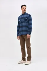 Sobrecamisa de algodón con diseño a cuadros en tonos azules, cuello clásico, cierre frontal con botones y dos bolsillos en el pecho con solapa.