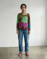 Remera de manga larga con estampa exclusiva de formas orgánicas y abstractas en tonos verdes, marrones, magenta y azul. Presenta un cuello redondo y una silueta relajada.