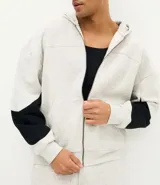 Buzo con capucha y cierre frontal, confeccionado en tejido fleece de algodón y poliéster. Presenta un diseño bicolor con cuerpo en gris melange y paneles laterales en las mangas de color negro, bolsillos frontales, y puños y ruedo en rib.