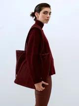 Cartera tipo totebag de cuero, color bordó, con diseño minimalista, interior espacioso y asas reforzadas.