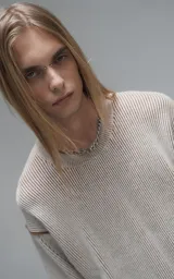 Sweater de punto con diseño de rayas verticales en tonos beige y marrón, cuello redondo y corte oversize.