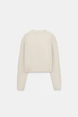 Jersey de punto de cuello redondo y manga larga, con acabado en rib en puños y ruedo.