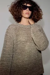 Jersey de punto con hilo metalizado, cuello redondo y manga larga, de diseño clásico y acabado texturizado.