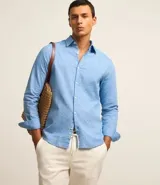 Camisa comfort masculina de lino y algodón color celeste, con cuello inglés, manga larga y abotonado delantero.