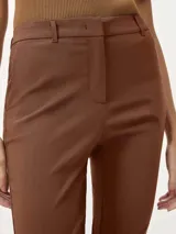 Pantalón sastrero de corte recto y ajuste entallado, con cintura de tiro medio, cierre frontal con botón y bolsillos laterales.