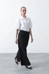 Pantalón wide leg de corte sastrero, color negro, con cintura de tiro medio y diseño de pernera amplia y relajada.