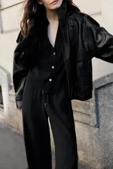 Pantalón fluido de tiro alto color verde militar, con cintura elástica ajustable con cordones y detalles de cuentas de madera. Tiene bolsillos delanteros y pierna recta.