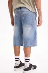 Bermuda de jean de algodón de estilo skater oversize en color negro, con diseño clásico de bolsillos y trabillas para cinto.
