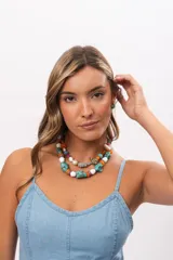 Collar corto compuesto por cuentas grandes de piedra turquesa irregular, alternadas con cuentas circulares blancas, naranjas y lilas.