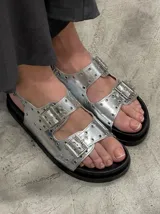 Sandalias plateadas con hebillas y suela track negra.