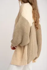 Cardigan de punto grueso con diseño color block en tonos beige, crema y verde oliva. Corte oversize y mangas largas.