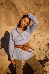 Cinturón de cuero con diseño de doble hebilla y correas superpuestas, pensado para usar a la altura de la cadera. Presenta una estructura de capas que aporta profundidad y detalle al accesorio.