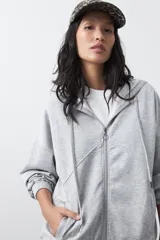 Campera con capucha y cierre frontal, de silueta relajada y estética deportiva. Presenta hombros caídos, bolsillos laterales, terminaciones elastizadas en puños y líneas de recorte en el frente.