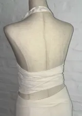 Conjunto de top halter y falda midi al cuerpo, color blanco. El top tiene escote profundo y está decorado con lentejuelas.