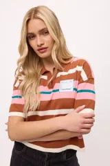 Remera tejida de algodón con cuello polo amarillo, corte boxy y estampado de rayas horizontales en tonos azul claro, marrón, rojo y amarillo.