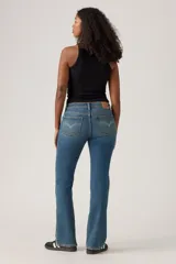 Jeans de mujer de tiro bajo, color azul medio con efecto lavado, corte bootcut y cierre de botón y cremallera.
