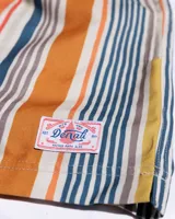 Short de baño con rayas verticales en tonos naranja, amarillo, gris y azul. Cintura elastizada con cordón ajustable.