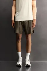 Shorts deportivos de entrenamiento Zara Athleticz, color beige, confeccionados en tejido técnico ligero y elástico con forro interior. Presentan cintura elástica ajustable, bolsillos frontales, bolsillo trasero de seguridad con cierre, aberturas laterales en el bajo y detalle de logo estampado en la pierna.