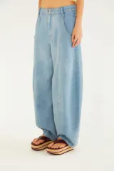 Jeans de denim celeste con diseño tipo globo, corte ancho y cintura alta con trabillas y cierre frontal con botón y cremallera.