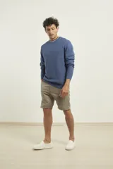 Sweater de punto fino azul con cuello redondo y terminaciones elásticas en canalé.